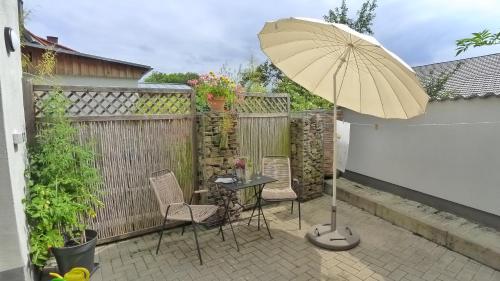 a patio with a table and chairs and an umbrella at Ferienhaus 13b in Bad Orb