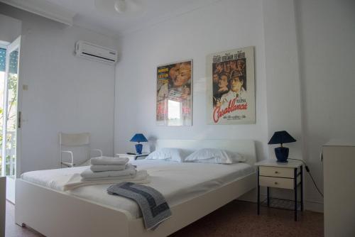 a white bedroom with two movie posters on the wall at Mario's Apartment in Neos Marmaras