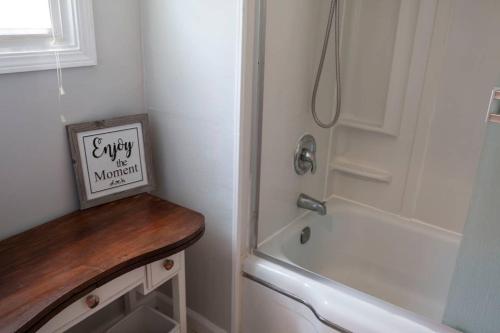 a bathroom with a shower and a sign on a counter at West End Neighborhood Cottage in Santa Rosa