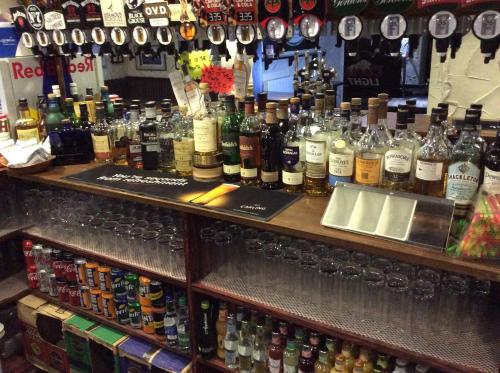 un bar con un montón de botellas de alcohol en The Stag Hotel en Banchory