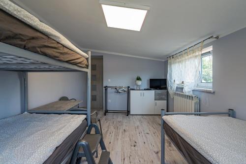a room with two bunk beds and a kitchen at Pokoje nad Odrą Wały in Brzeg Dolny