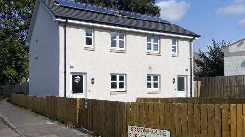 a white house with solar panels on it at BroomHouse HomeStay in Edinburgh