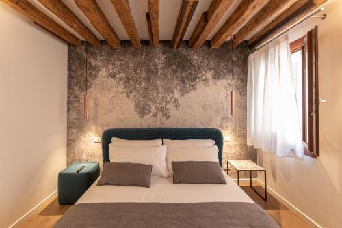 a bedroom with a large bed with a wall at La Finestra sulle Beccarie in Venice