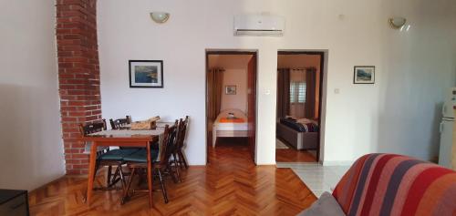 uma sala de estar com uma mesa e uma sala de jantar em Apartman Suky em Sukošan