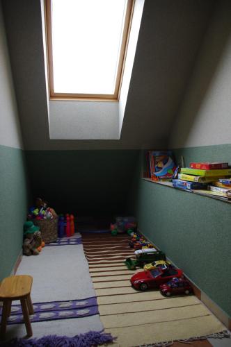 a attic room with a lot of toys and a window at Hóvirág Panzió in Porva