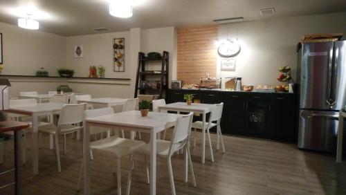 Un restaurante con mesas blancas y sillas blancas y un refrigerador. en Travelodge by Wyndham Edmonton East, en Edmonton
