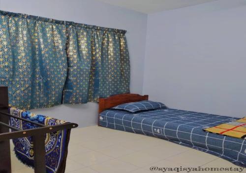 a bedroom with a bed and a curtain at Syaqisya Homestay in Seri Manjung