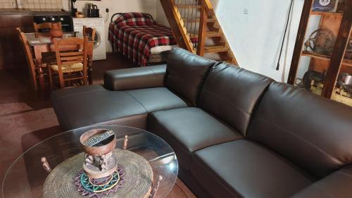 a living room with a leather couch and a glass table at Zangoulos Villa in Kakopetria