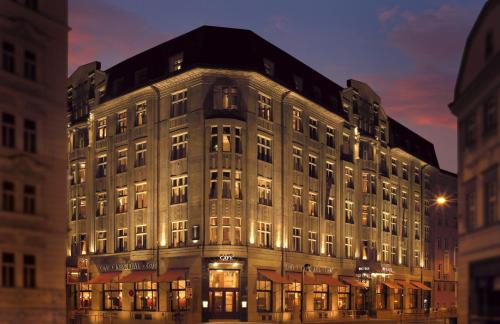 Un grand bâtiment est éclairé la nuit. dans l'établissement Art Deco Imperial Hotel, à Prague