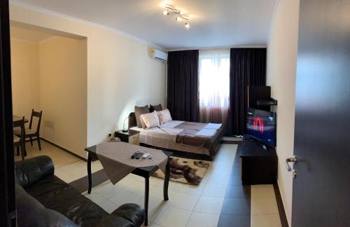 ein Wohnzimmer mit einem Sofa, einem Bett und einem TV in der Unterkunft Lux Studio Gabrovo in Gabrowo