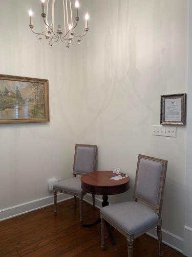 a room with two chairs and a table and a chandelier at The Kendall in Boerne