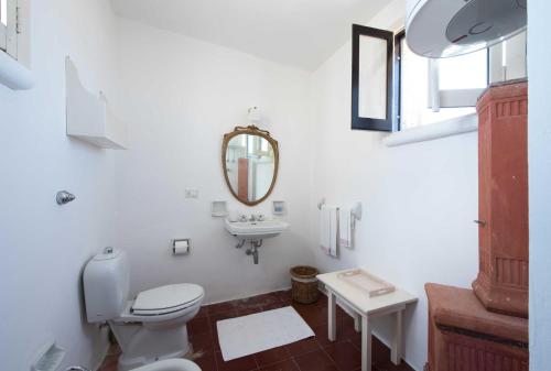 a white bathroom with a toilet and a sink at Castello di Casamassella - Marea Stays Collection in Casamassella