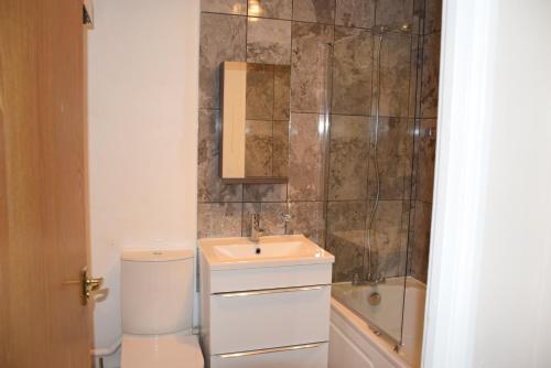 a bathroom with a toilet and a sink and a shower at 1 Bedroom Apartment Ponders End in London