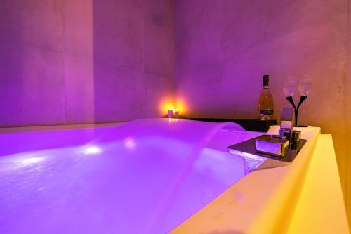 a purple room with a tub with a bottle of wine at Al Castello Luxury B&B in Reggio di Calabria