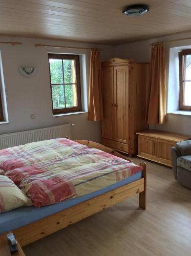 a bedroom with a bed and a couch and windows at Landhotel Quelle in Heidersdorf