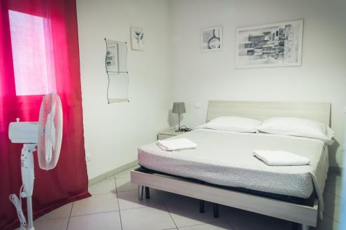 Un dormitorio con una cama y una cortina roja. en Pisacentro Guest House, en Pisa