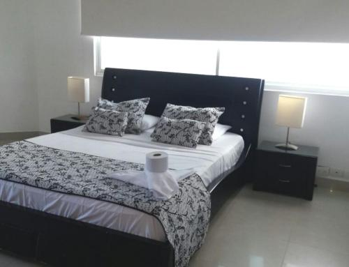 ein Schlafzimmer mit einem großen Bett mit zwei Lampen in der Unterkunft Apartamento con Piscina Cartagena en el Laguito Bocagrande in Cartagena de Indias