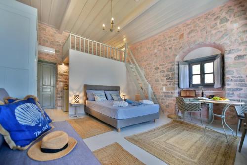 a living room with a bed and a staircase at Port Mansion Studio 2 Hydra - first floor not a hotel - no cl eaning while guests inside in Hydra