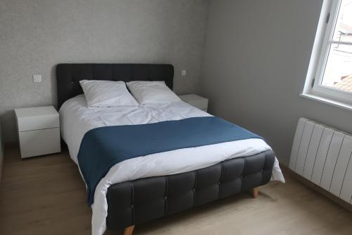 - un lit avec une couette bleue et blanche dans une chambre dans l'établissement Aux Portes du Beaujolais, à Belleville-sur-Saône