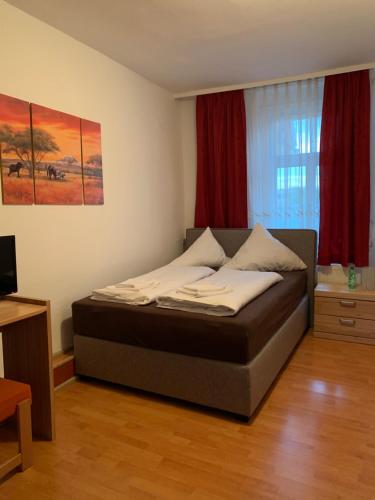 um quarto com uma cama num quarto com cortinas vermelhas em Linde Restaurant & Hotel em Trossingen