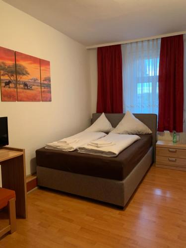 a bedroom with a bed in a room with red curtains at Linde Restaurant & Hotel in Trossingen