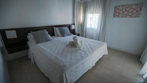 a bedroom with a bed with a teddy bear on it at Sea Point By D&G in Carilo