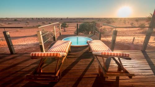 two chairs and a swimming pool on a deck at Bagatelle Kalahari Game Ranch in Hardap