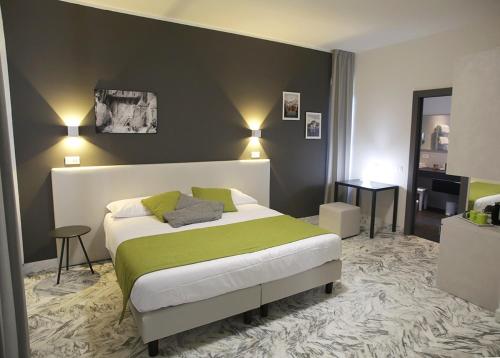 a bedroom with a large bed with a green blanket at Mikeme in Carrara