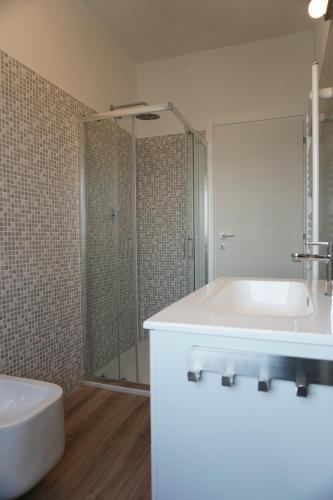 bagno con vasca, lavandino e doccia di Appartamento Tramonto a Chioggia
