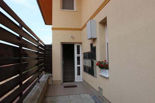 a hallway of a building with a door and flowers in a window at Fortuna Lux apartments in Hévíz