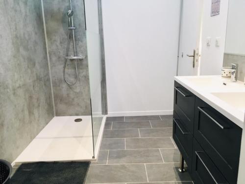 une salle de bain avec une douche avec une porte vitrée dans l'établissement Le Moulin de la Vollerie, à La Tourlandry