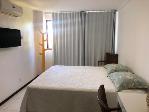 una camera con letto e tavolo con sedie di Barra Bali - Luxo e Paraiso a Barra de São Miguel