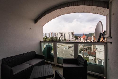 a balcony with a couch and a view of a city at Penzion Bardejov in Bardejov