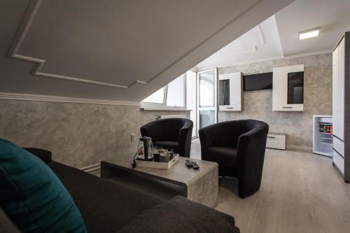 a living room with two chairs and a couch at Penzion Bardejov in Bardejov