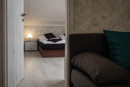 a small bedroom with a bed and a couch at Penzion Bardejov in Bardejov