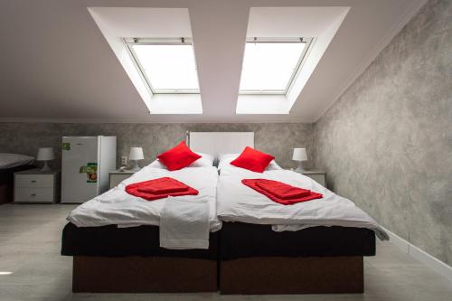 a bedroom with a large bed with red pillows at Penzion Bardejov in Bardejov