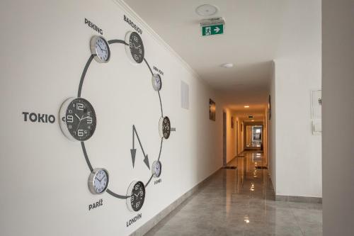 a wall with clocks on it in a hallway at Penzion Bardejov in Bardejov