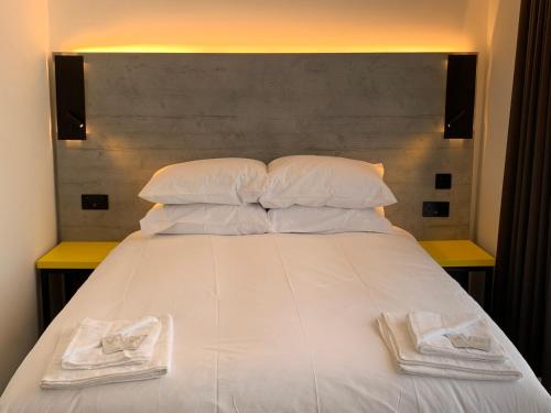a bed with a white bedspread and pillows at Motel Air Glasgow Airport in Paisley
