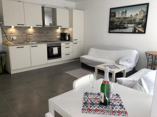 a kitchen and a living room with a table at Apartment EG in Oststeinbek