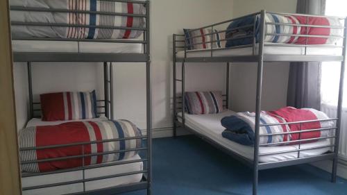 a bed room with two bunk beds and a wall mounted wall mounted wall mounted at The Queens Hostel in London