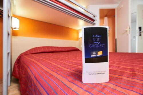 a hotel room with a bed with a sign on it at Premiere Classe Montreuil in Montreuil