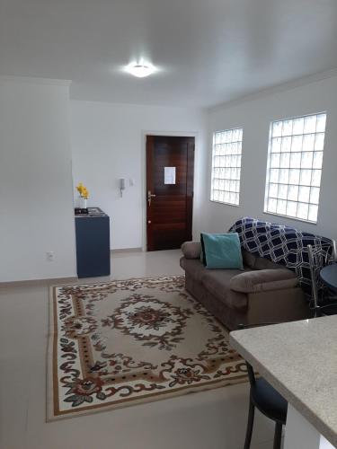 Apartamento Santa Ana في ساو جواكيم: غرفة معيشة مع أريكة وطاولة