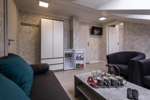 uma sala de estar com um sofá, uma mesa e um frigorífico em Penzion Bardejov em Bardejov