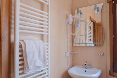 La salle de bains est pourvue d'un lavabo et d'un miroir. dans l'établissement Hostal Tribal, à Puebla de Sanabria