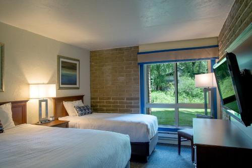 Sandstone Creek Club Condominiums في فيل: غرفة فندقية بسريرين ونافذة