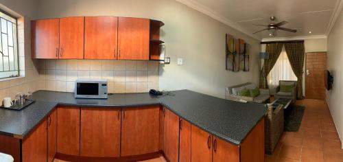 a kitchen with wooden cabinets and a counter top at Polokwane Lodge in Polokwane