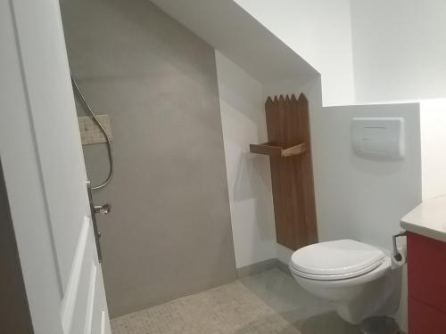 a white bathroom with a toilet and a sink at Cottage B2 Bazenville in Bazenville