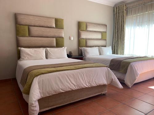 Кровать или кровати в номере Polokwane Lodge