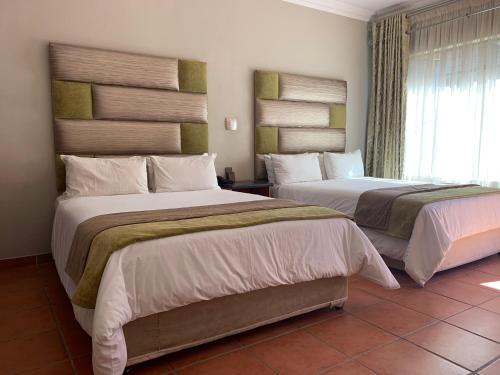 Postel nebo postele na pokoji v ubytování Polokwane Lodge