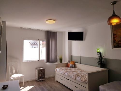 een kleine slaapkamer met een bed en een raam bij Lolita's house torre del oro in Sevilla